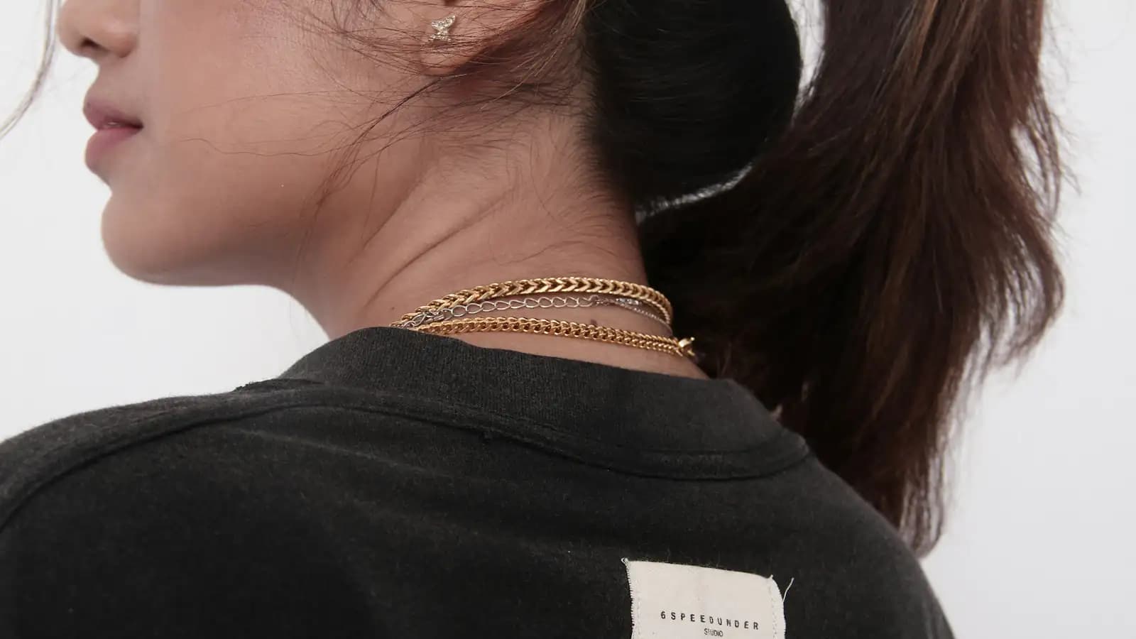 Mulher de costas usando colar dourado